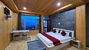 A bedroom with a bed, a desk, and a window with a view. - Lucky Homestay (Theog)