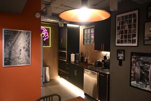 Una cocina moderna con electrodomésticos de acero inoxidable, un armario de madera y un letrero de neón.