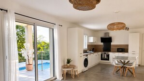 Une cuisine moderne avec un coin repas, un lave-linge et une vue sur une piscine.
