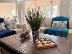 A wooden table with a decorative plant, a tray of dried flowers, and a wooden tray with starfish-shaped cookies.