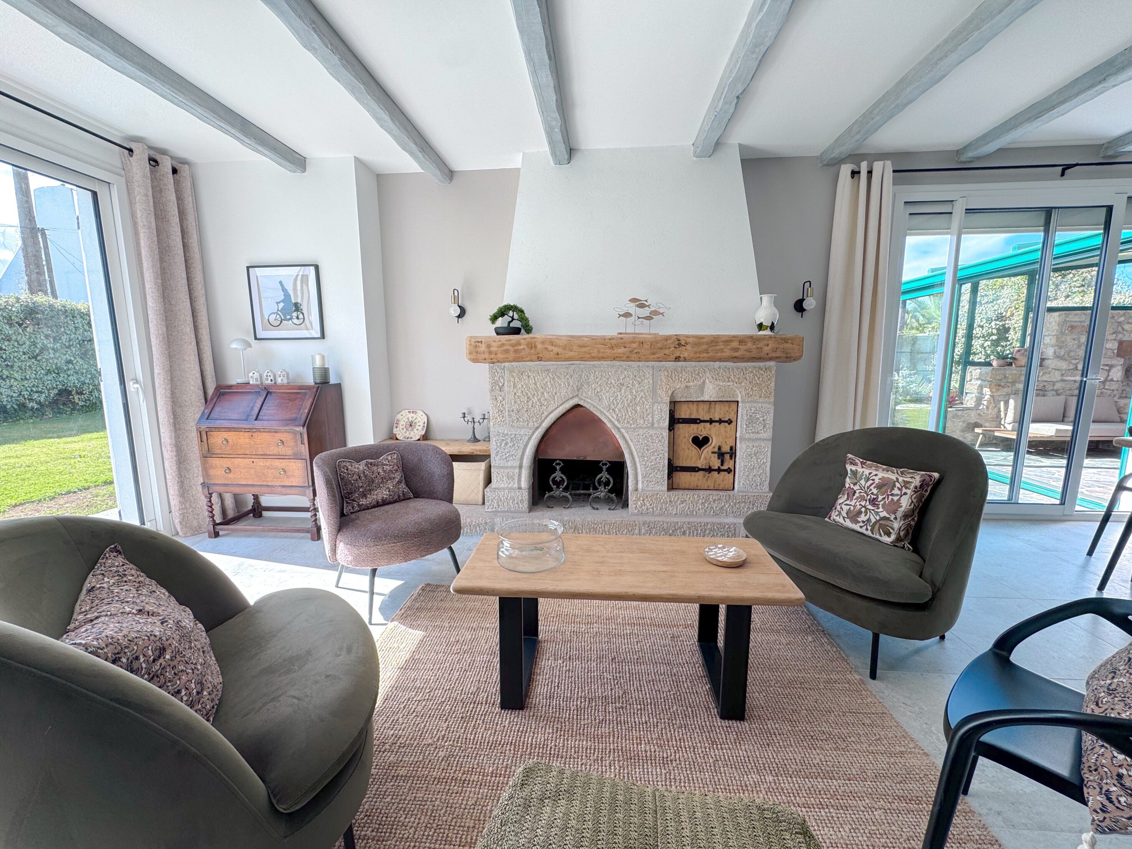 Een moderne woonkamer met een open haard, comfortabele zithoek en uitzicht op de omgeving.