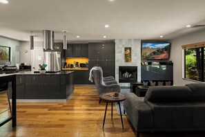 A modern kitchen with a central island, dark cabinetry, and stainless steel appliances. - Sedona Wellness Retreat: Gym + Sauna + Steam + Tub (Sedona)