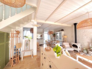 A spacious living area with a staircase, dining table, and a fireplace. - Holiday Home “Léchiagat” with Private Terrace and Wi-Fi (Treffiagat)