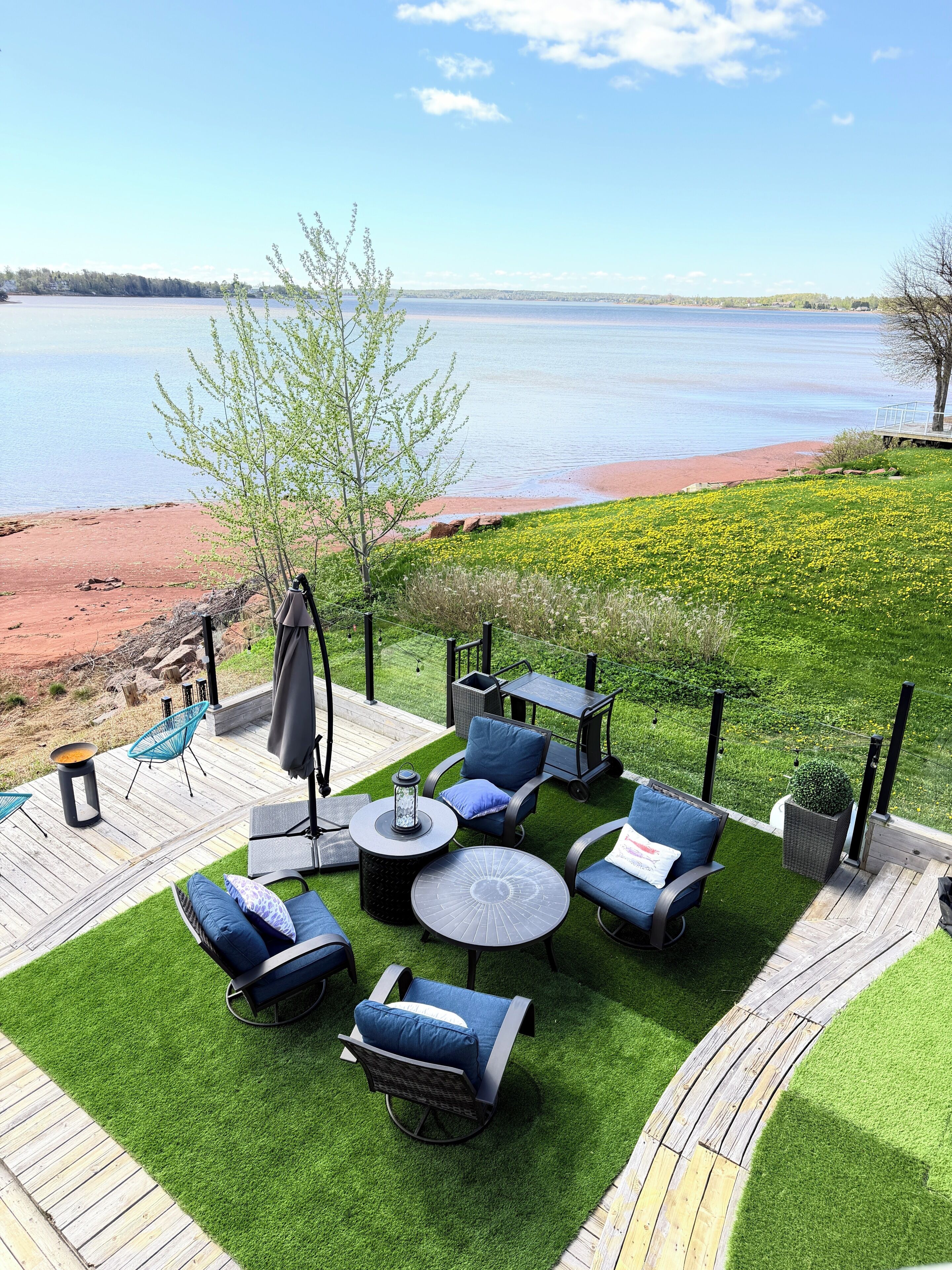 Un patio con mobili da esterno, un braciere e vista sull'acqua.