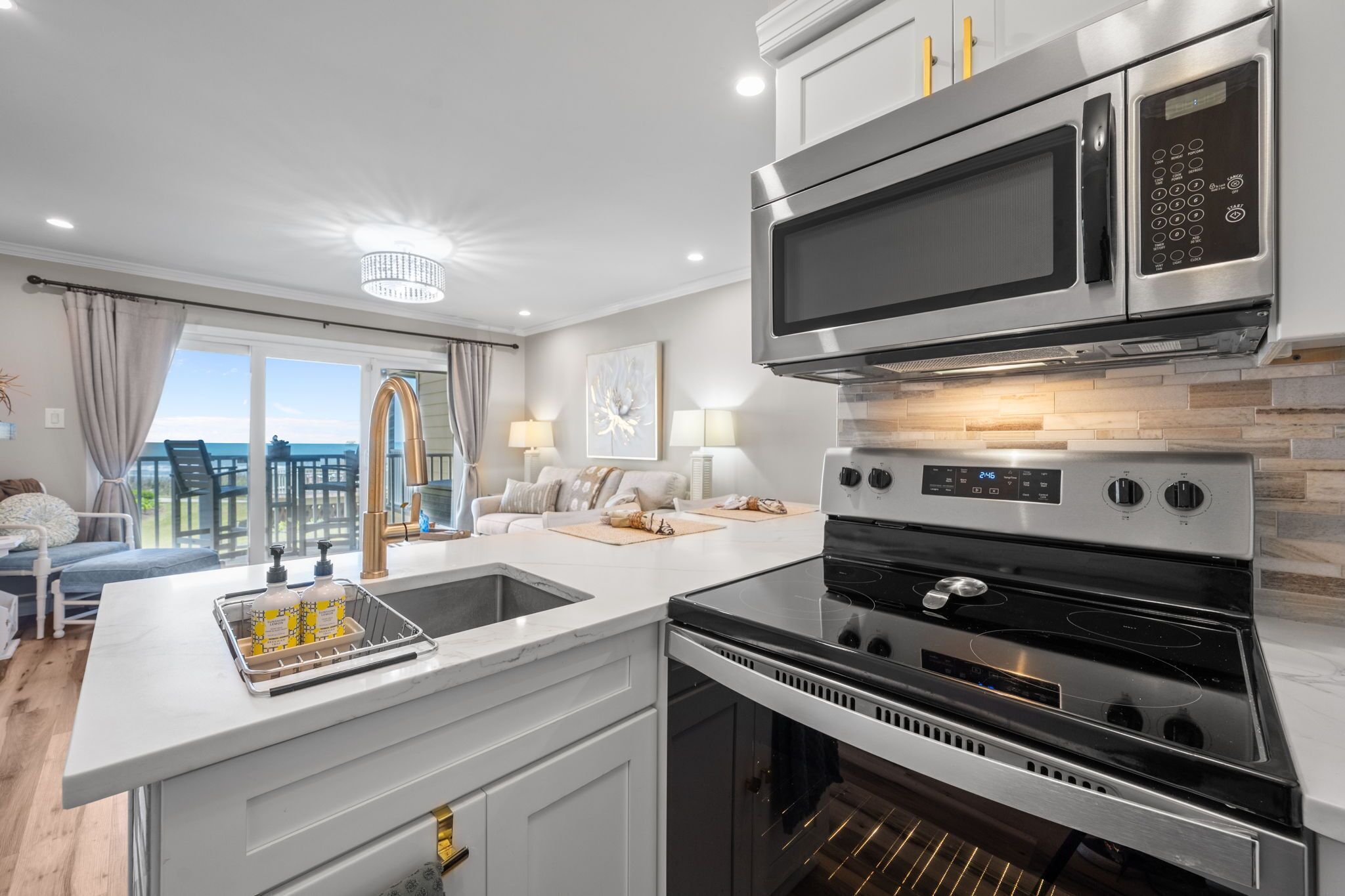A modern kitchen with a built-in oven, microwave, and a large island with a sink.