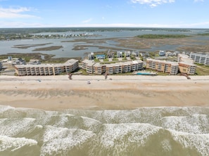 A coastal hotel with multiple buildings, a sandy beach, and a view of the sea. - Heron’s Reserve | Oceanfront + Beach Access (North Topsail Beach)