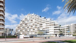 A multi-story residential building with balconies, a pedestrian walkway, and a grassy area in front. - AG DUPLEX 2-3 PREMIUM - only families (Playa de Gandía)