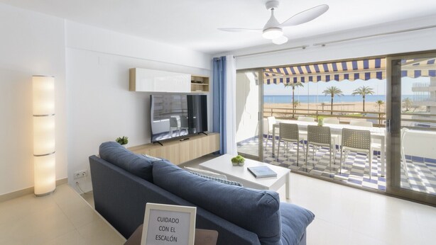 A modern living room with a sofa, TV, and a balcony with a checkered floor and outdoor seating. - AG DUPLEX 2-3 PREMIUM - only families (Playa de Gandía)