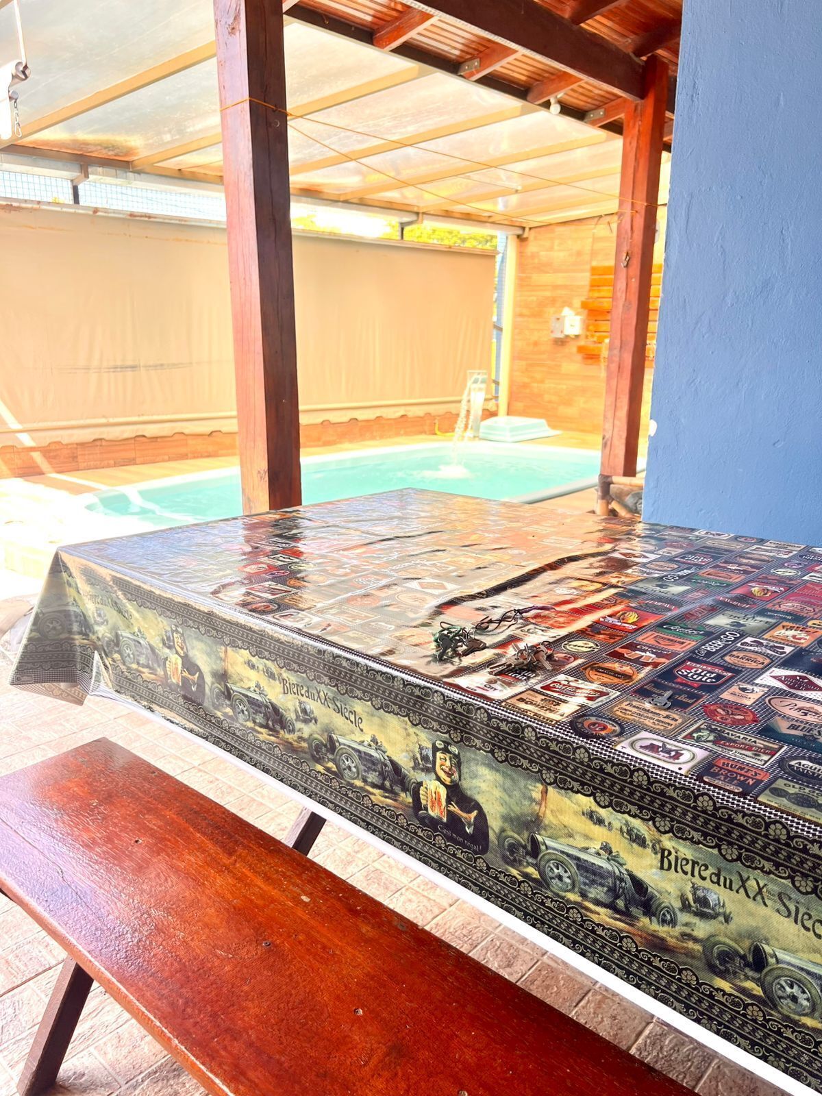 Un banco de madera con una mesa adornada con etiquetas antiguas de cerveza.