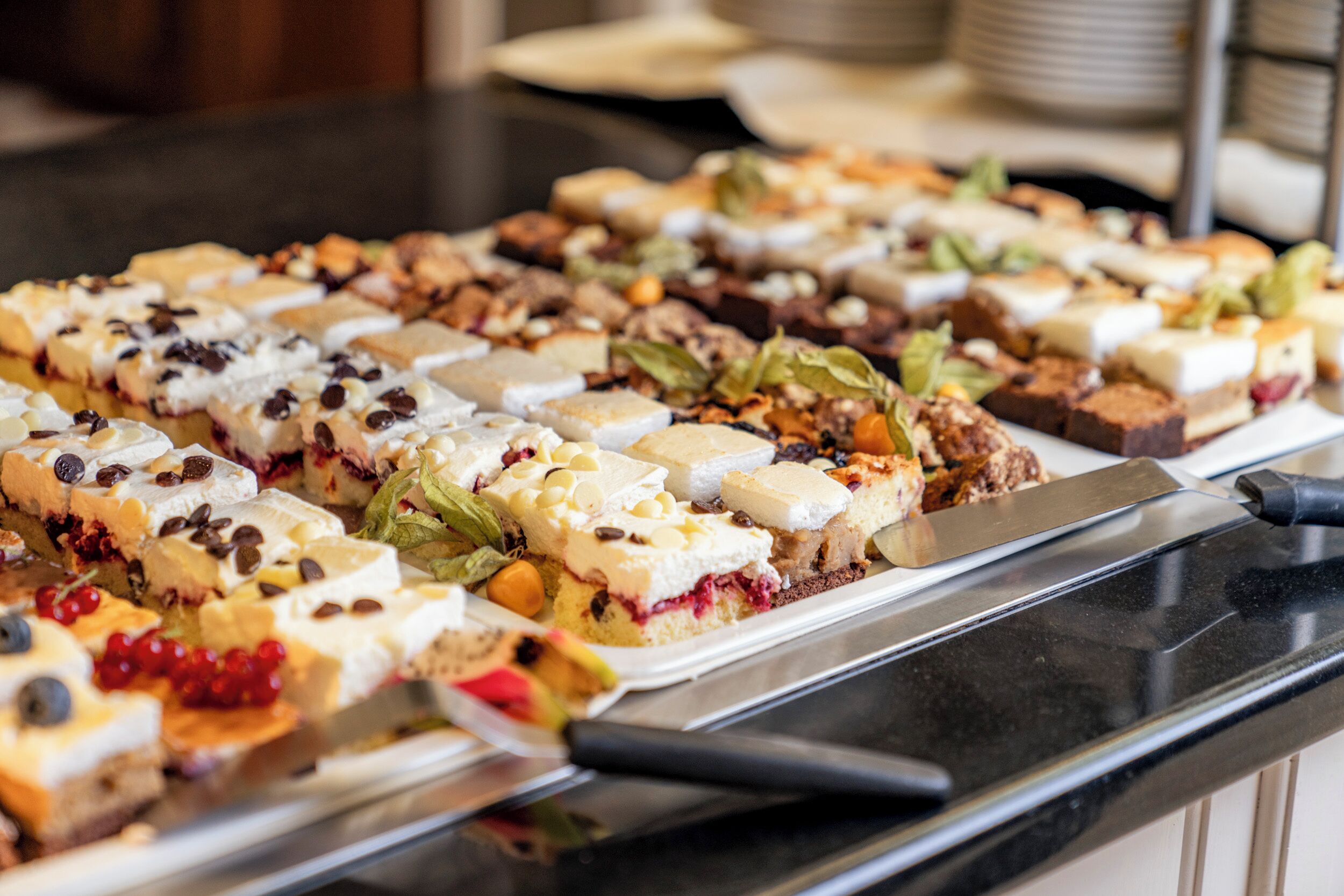 Ein Buffet mit verschiedenen Desserts, die auf einer Platte angerichtet sind.