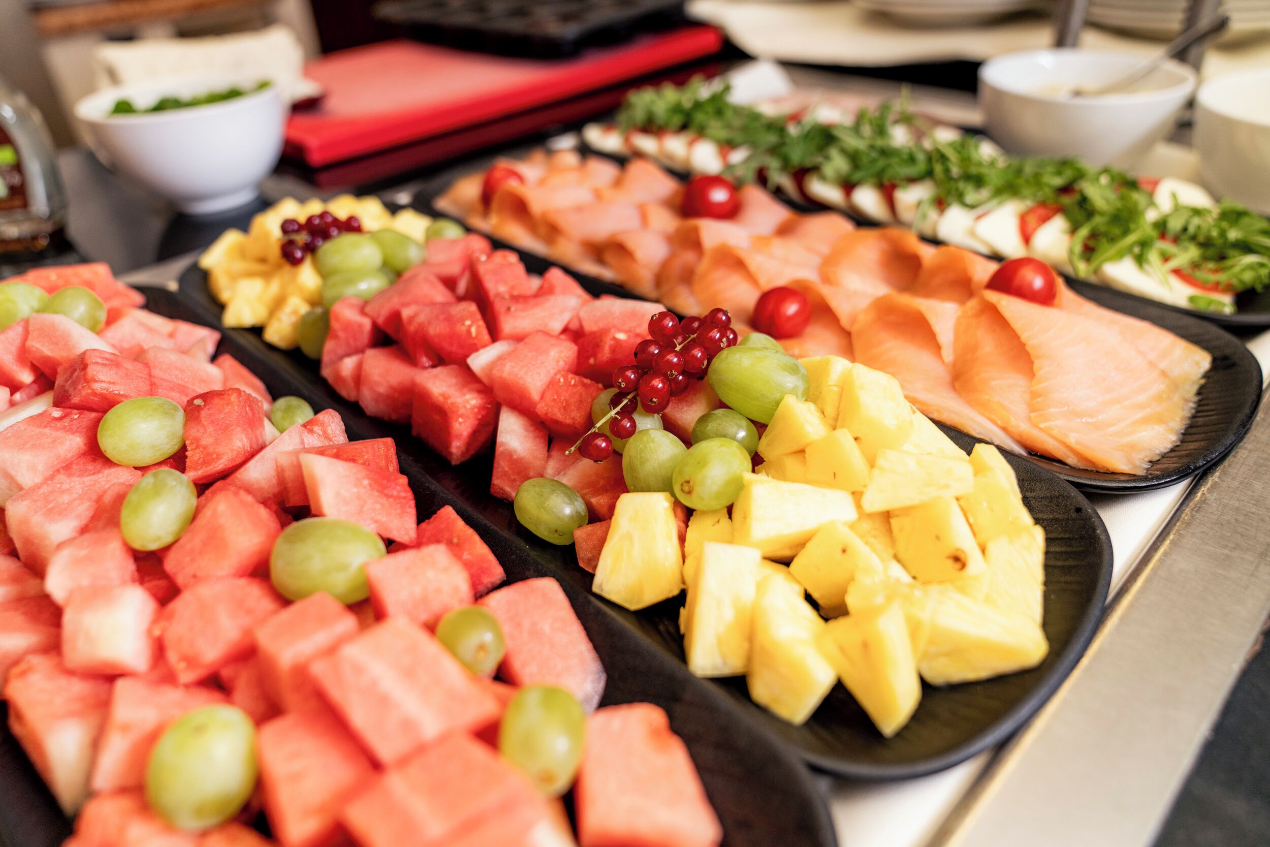 A buffet with various fruits and deli items.