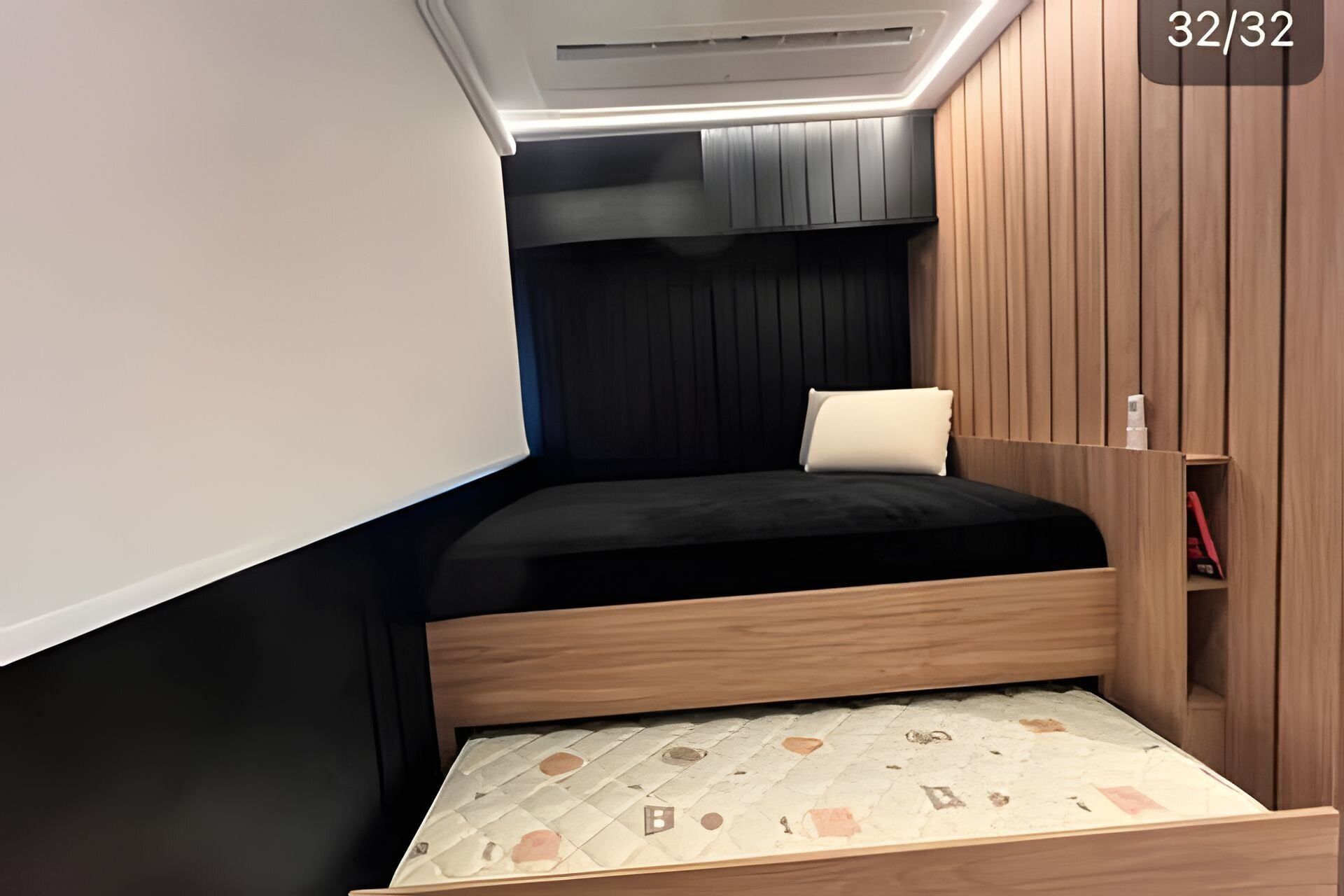 A compact room with a bed, built-in wardrobe, and a sloped ceiling.