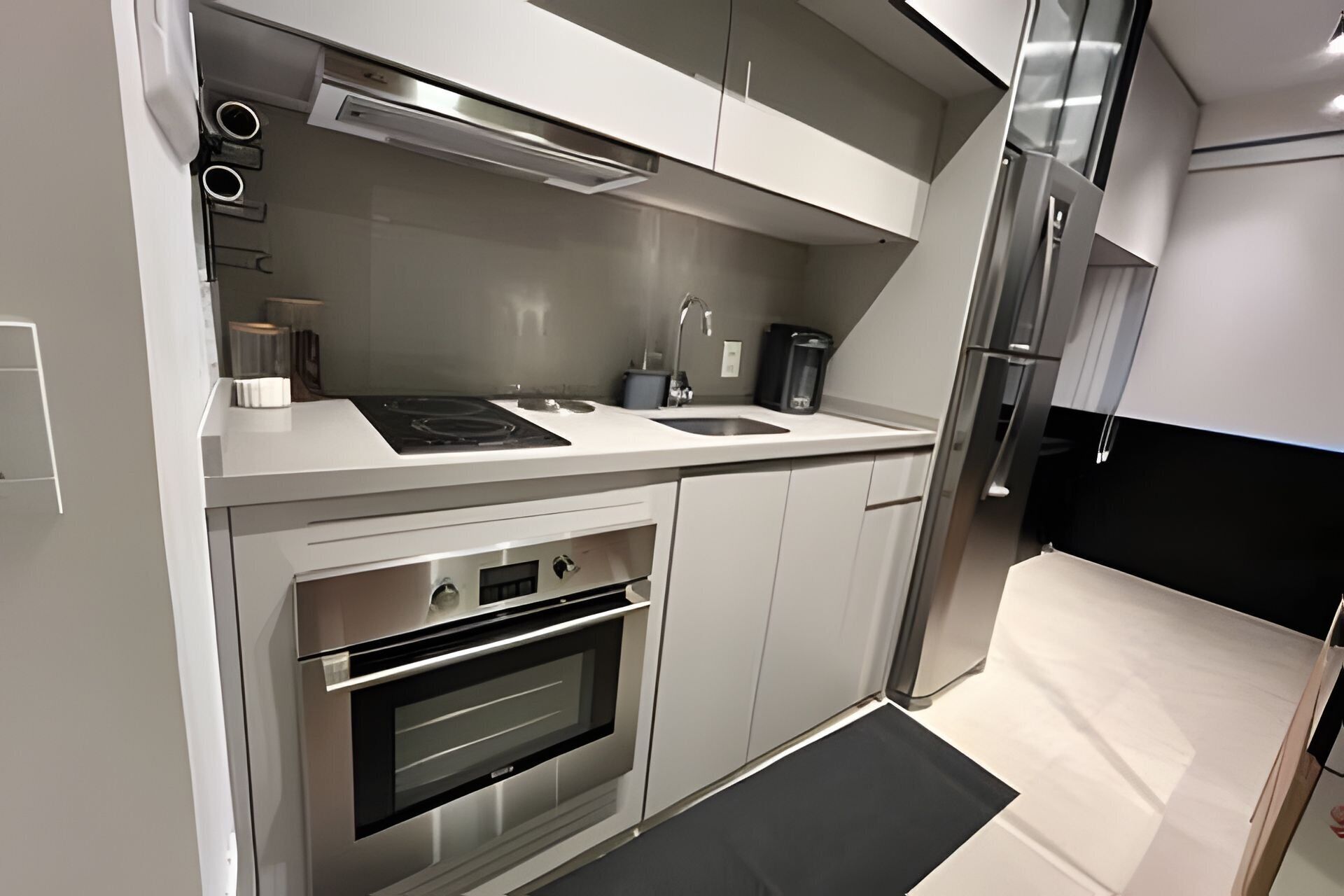 A modern kitchen with a built-in oven, a stovetop, and a sink.