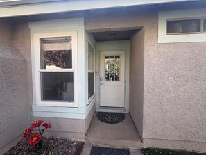 A house with a white door, a window with blinds, and a small garden with red flowers. - Vegas Hideaway conveniently located from airport and strip 8-20 minutes. . . (Las Vegas)