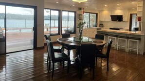 A modern kitchen with a large island, white cabinets, and a view of a lake.