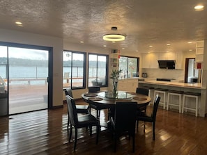 Una cocina moderna con una isla grande, armarios blancos y vistas a un lago.
