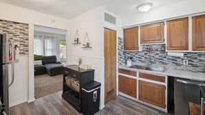 A modern kitchen with wooden cabinets, a stainless steel refrigerator, and a built-in oven. - Airport Getaway -2BR near Detroit sports & events 20 min from Downtown A2 (Taylor)