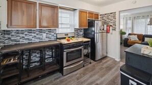 A modern kitchen with wooden cabinets, a stainless steel refrigerator, and a built-in oven. - Airport Getaway -2BR near Detroit sports & events 20 min from Downtown A2 (Taylor)