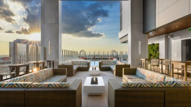 Terraza en la azotea con asientos, piscina y vistas de la ciudad.