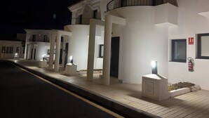 Μια σειρά από λευκά κτίρια με μπαλκόνια, ένας πυροσβεστήρας και μια πινακίδα που υποδεικνύει την έξοδο.