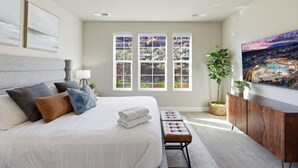 A bedroom with a bed, a bench, a TV, and a window with a view. - Game loft, Nerf Wars, Resort Pool, Lazy River & Waterslide • Near Zion (Washington)