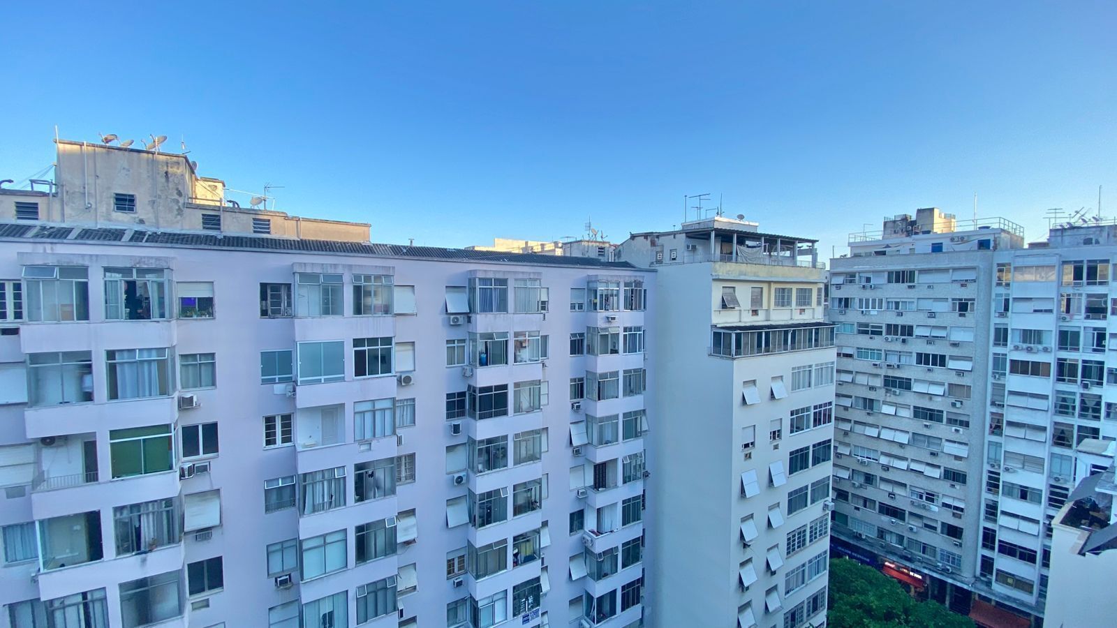 Un edificio residenziale alto con numerosi balconi, ampie finestre e cielo sereno.