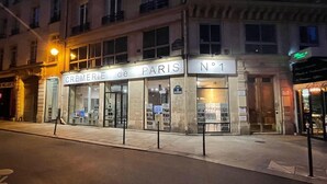 Um edifício com uma placa indicando 'CREMERIE de PARIS N°1' e uma entrada visível.
