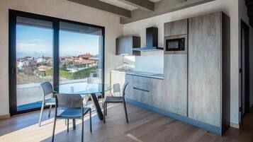 Apartamento Deluxe, balcón, vistas a la piscina | Cocina privada | Frigorífico, microondas, placa de cocina y lavavajillas