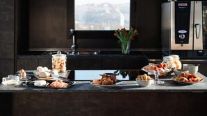 A kitchen counter with various food items and a coffee machine. - Vineho (Barolo)