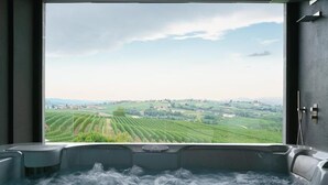 A hot tub with a view of a green landscape. - Vineho (Barolo)