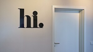 Valkoinen ovi, jonka yläpuolella on pelkistetty seinäkilpi.