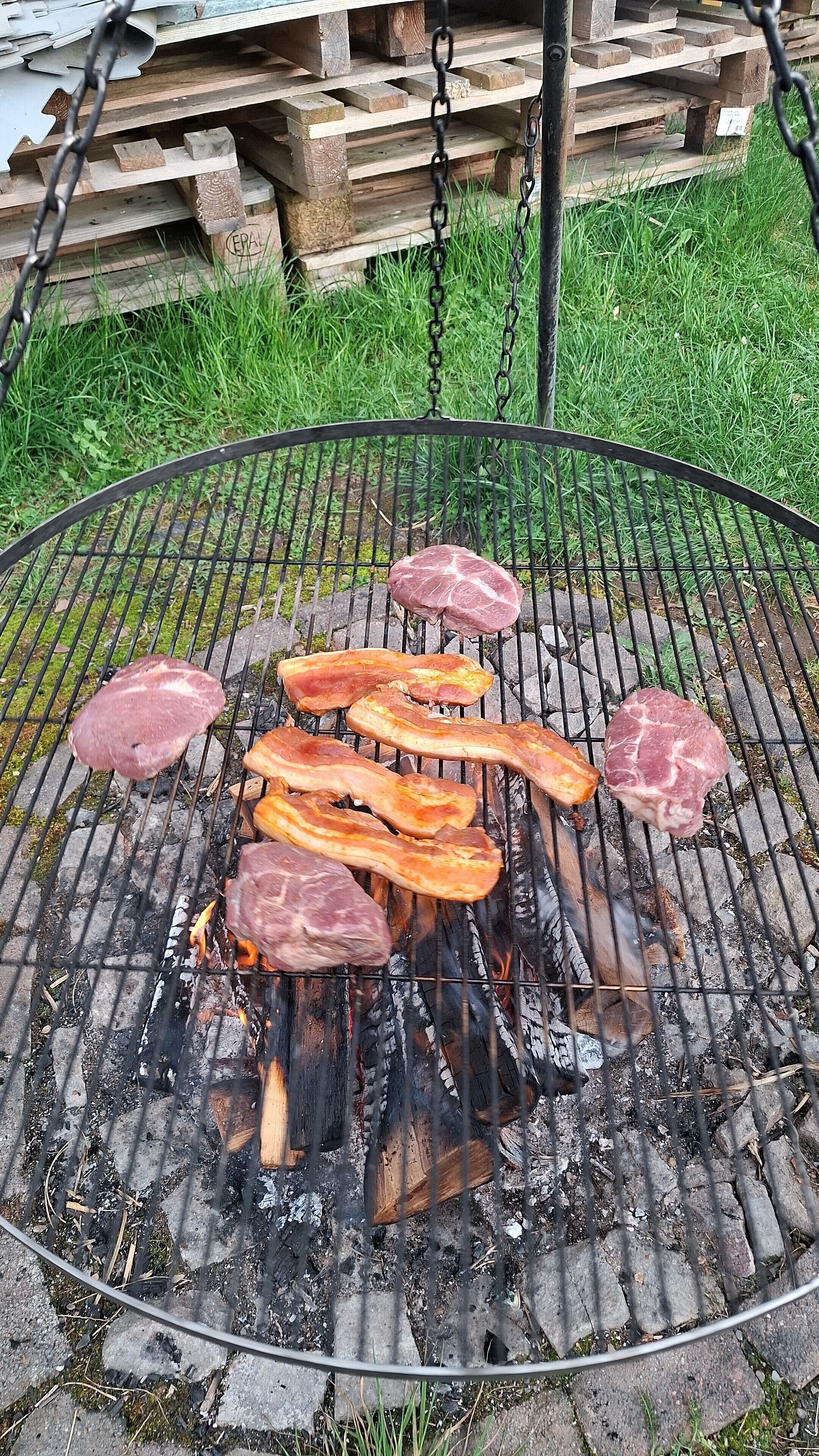 A grill with meat cooking over charcoal.