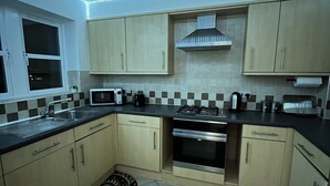 A kitchen with a microwave, stove, sink, and cabinets. - Perfect Spacious & Comfortable 2-bedroom Apartment in Derby for a relaxing stay (Derby)