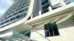 A modern building with a glass facade, a prominent entrance, and a sign reading 'bahamas'.