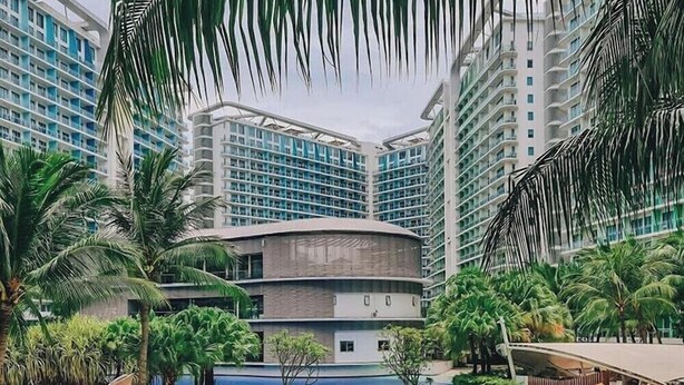 A resort with a pool, palm trees, and modern buildings.