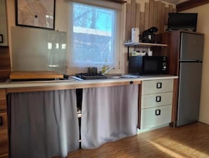 A kitchen with a wooden countertop, a sink, a microwave, a refrigerator, and a window with curtains. - Mobilhome in a 3* campsite in argeles sur mer sleeps 6 (Argelès-sur-Mer)
