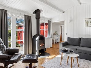 A cozy living room with a fireplace, a sofa, a coffee table, and a view of the outdoors. - "Swea" - 2.5km from the sea by Interhome (Højby)