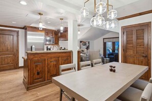 A spacious kitchen with wooden cabinets, a large island, and pendant lighting.
