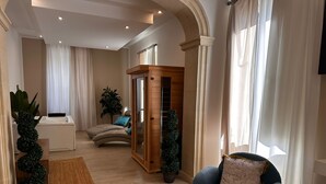 En moderne stue med en buet sofa, en blå lænestol og et træskab.