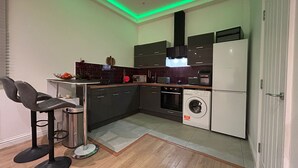 A compact kitchen with a washing machine, a microwave, and a sink.