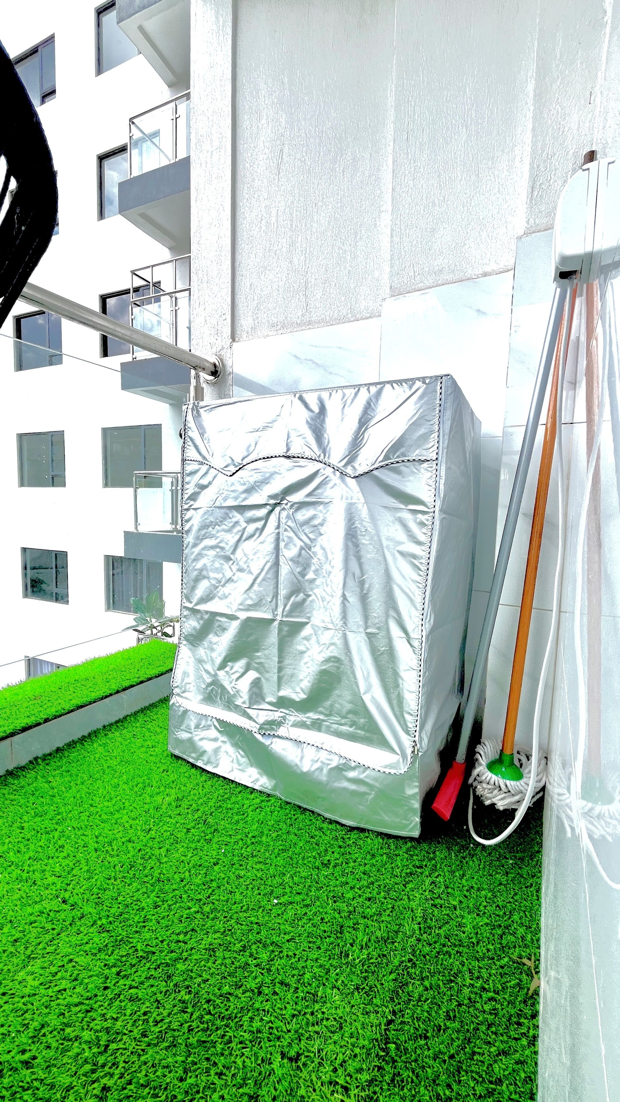 Een kamer met een vloer van groen kunstgras, een witte muur en een metalen constructie.