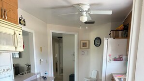 A kitchen with a stove, microwave, ceiling fan, and a rug. - Poolside Cozy 2 bedroom pet friendly perfect getaway (Port Charlotte)