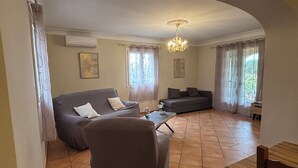 A living room with a sofa, armchair, and a coffee table. - Villa Du Grand Noyer (Lorgues)