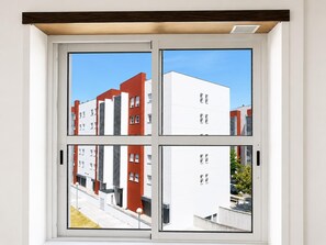 A window with a view of a modern building complex. - Spacious Lisbon Apartment With 4 Bedrooms (Lisbon)