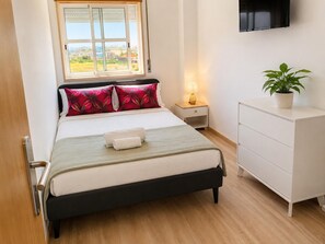 A neatly arranged bedroom with a bed, bedside table, lamp, and a potted plant. - Spacious Lisbon Apartment With 4 Bedrooms (Lisbon)