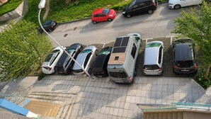 A parking area with multiple cars, a solar panel on a vehicle, and a staircase leading to an upper level. - Spacious Lisbon Apartment With 4 Bedrooms (Lisbon)
