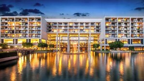 A multi-story hotel with balconies, a central courtyard, and a reflective pool. - StageCoach Weekend Stay – Luxury 2BR Villa - Sleeps 8! (Palm Desert)