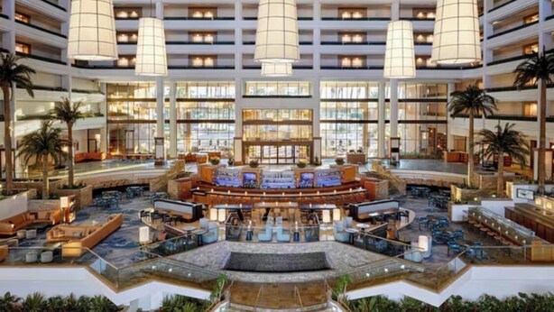 A spacious lobby with a central bar area, multiple seating zones, and a staircase leading to upper floors. - StageCoach Weekend Stay – Luxury 2BR Villa - Sleeps 8! (Palm Desert)