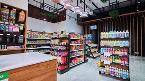 Ein modernes Supermarkt-Interieur mit Holzbögen, einem Empfangsschalter und hängenden Pflanzen.