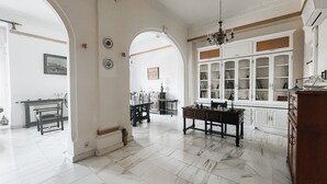 A spacious room with a marble floor, a dining table, and a large window with white cabinets. - Unique sunlit house overlooking the Acropolis (Athina)